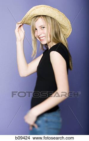 Portrait of a girl holding her hat View Large Photo Image Picture - Portrait of a girl holding her hat. Fotosearch