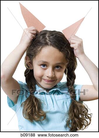 Portrait of a girl holding paper horns over her head View Large Photo Image Stock Photo - Portrait of a girl holding paper horns over her head. Fotosearch