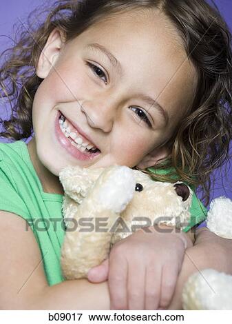 Portrait of a girl hugging a teddy bear View Large Photo Image Stock Photo - Portrait of a girl hugging a teddy bear. Fotosearch
