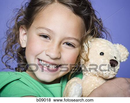 Portrait of a girl hugging a teddy bear View Large Photo Image Stock Photo - Portrait of a girl hugging a teddy bear. Fotosearch