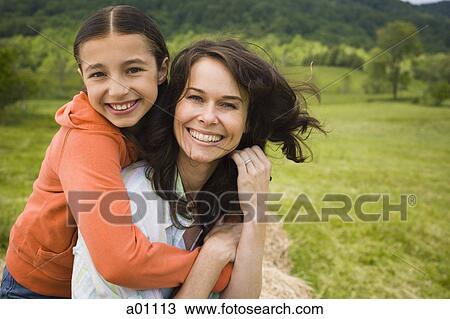 Portrait of a girl hugging her mother from behind View Large Photo Image Stock Image - Portrait of a girl hugging her mother from behind. Fotosearch