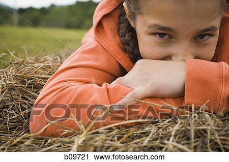 Portrait of a girl leaning over a haystack View Large Photo Image Stock Image - Portrait of a girl leaning over a haystack. Fotosearch