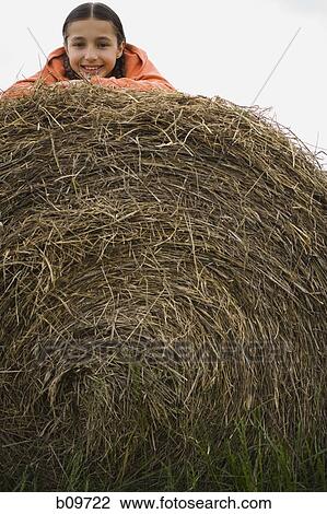 Portrait of a girl lying on a haystack View Large Photo Image Stock Image - Portrait of a girl lying on a haystack. Fotosearch