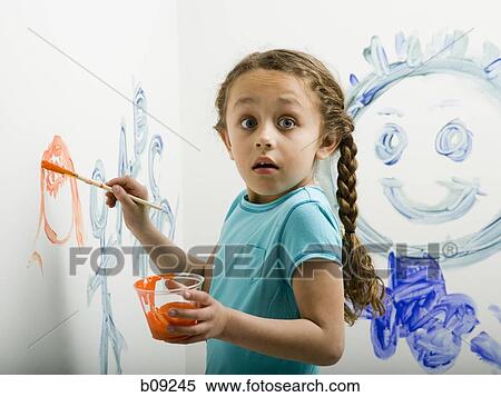 Stock Photography - Portrait of a girl painting on a wall. Fotosearch