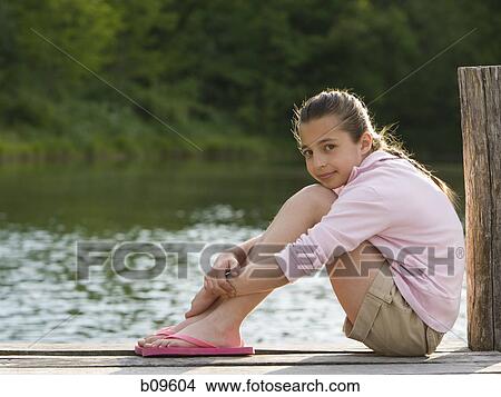 Portrait of a girl sitting on a pier View Large Photo Image Picture - Portrait of a girl sitting on a pier. Fotosearch