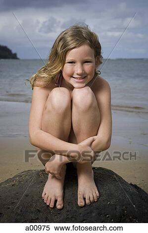 Portrait of a girl sitting on a rock and hugging her knees View Large Photo Image Stock Photography - Portrait of a girl sitting on a rock and hugging her knees. Fotosearch