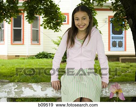 Portrait of a girl sitting on a wooden fence View Large Photo Image Stock Photo - Portrait of a girl sitting on a wooden fence. Fotosearch