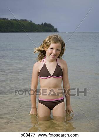 Stock Photo - Portrait of a girl standing in water. Fotosearch