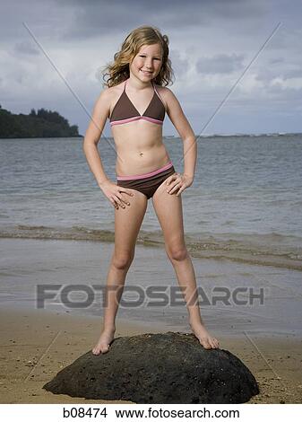 Picture - Portrait of a girl standing on a rock. Fotosearch