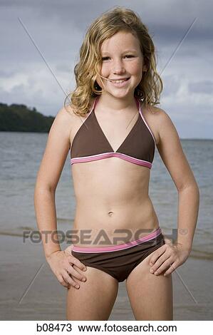 Stock Image - Portrait of a girl standing with hands on hips. Fotosearch