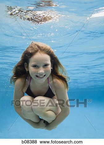 Stock Photo - Portrait of a girl swimming underwater. Fotosearch