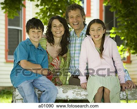 Portrait of a man and a mid adult woman smiling with their children View Large Photo Image Stock Image - Portrait of a man and a mid adult woman smiling with their children. Fotosearch