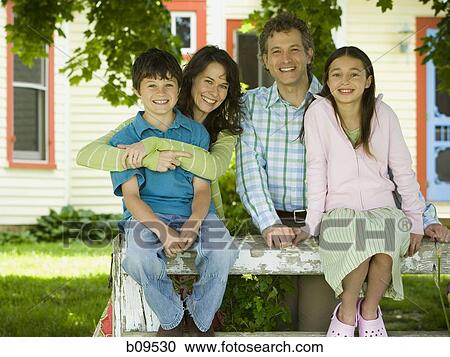 Stock Image - Portrait of a man and a woman smiling with their children. Fotosearch