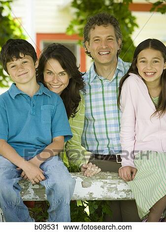 Stock Image - Portrait of a man and a woman smiling with their children. Fotosearch