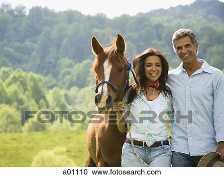 Portrait of a man and a woman standing with a horse View Large Photo Image Stock Image - Portrait of a man and a woman standing with a horse. Fotosearch