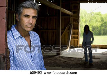 Portrait of a man and a woman standing behind him View Large Photo Image Stock Image - Portrait of a man and a woman standing behind him. Fotosearch