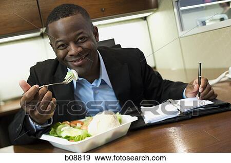 Portrait of a man eating in the office View Large Photo Image Stock Photo - Portrait of a man eating in the office. Fotosearch