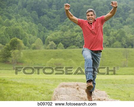 Portrait of a man jumping on a hay bale View Large Photo Image Stock Image - Portrait of a man jumping on a hay bale. Fotosearch