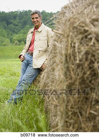 Portrait of a man leaning against a hay bale View Large Photo Image Stock Photo - Portrait of a man leaning against a hay bale. Fotosearch