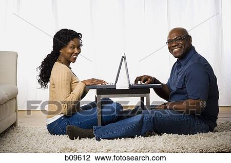 Stock Image - Portrait of a mature couple using laptops. Fotosearch