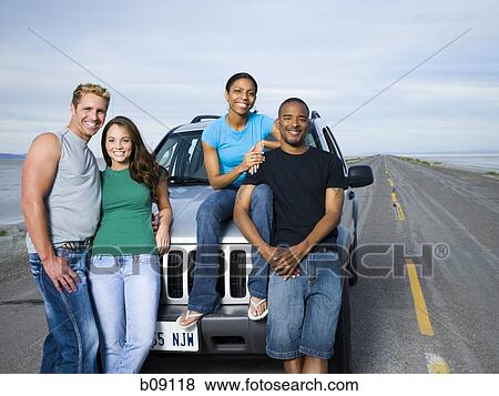 Portrait of a mid adult man and a young man smiling with two young women View Large Photo Image Stock Photo - Portrait of a mid adult man and a young man smiling with two young women. Fotosearch