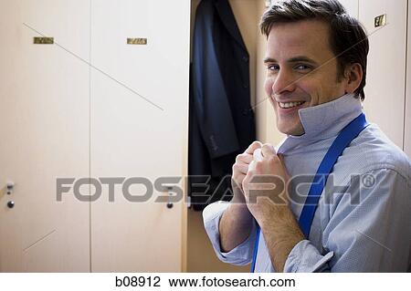 Portrait of a mid adult man buttoning his shirt View Large Photo Image Stock Image - Portrait of a mid adult man buttoning his shirt. Fotosearch