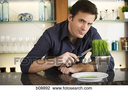 Portrait of a mid adult man holding a pair of scissors at a bar counter View Large Photo Image Stock Image - Portrait of a mid adult man holding a pair of scissors at a bar counter. Fotosearch