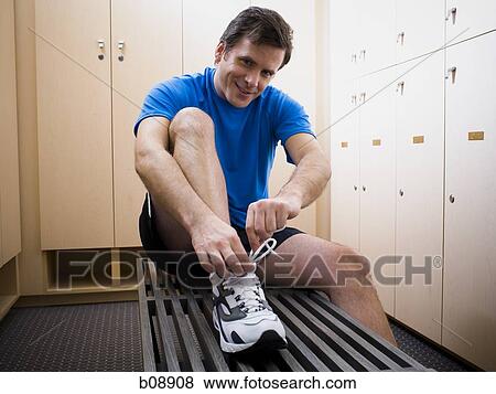 Portrait of a mid adult man tying his shoelaces View Large Photo Image Stock Photo - Portrait of a mid adult man tying his shoelaces. Fotosearch