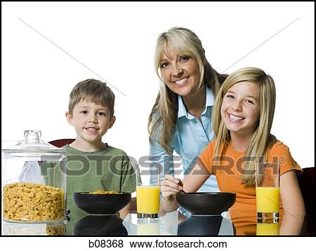 Portrait of a mid adult woman and her two children at the breakfast table View Large Photo Image Stock Photo - Portrait of a mid adult woman and her two children at the breakfast table. Fotosearch