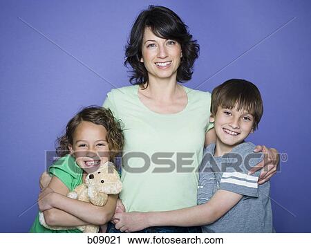 Portrait of a mid adult woman with her arm around her son and daughter View Large Photo Image Stock Image - Portrait of a mid adult woman with her arm around her son and daughter. Fotosearch
