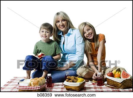 Stock Photo - Portrait of a mother and her two children having a picnic. Fotosearch