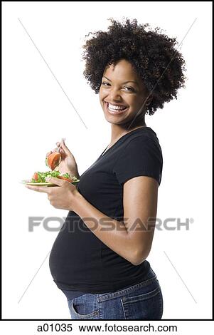 Portrait of a pregnant woman holding a plate of salad View Large Photo Image Stock Photography - Portrait of a pregnant woman holding a plate of salad. Fotosearch