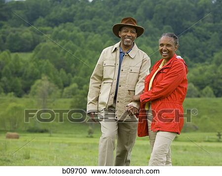Portrait of a senior man and a senior woman walking in a field View Large Photo Image Stock Image - Portrait of a senior man and a senior woman walking in a field. Fotosearch