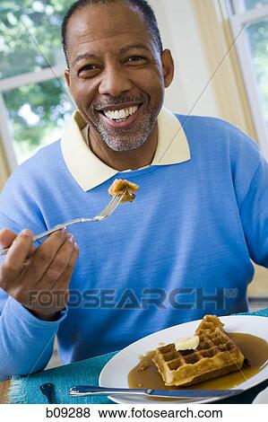 Stock Photo - Portrait of a senior man having breakfast. Fotosearch