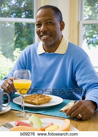 Portrait of a senior man sitting at the breakfast table View Large Photo Image Stock Photograph - Portrait of a senior man sitting at the breakfast table. Fotosearch