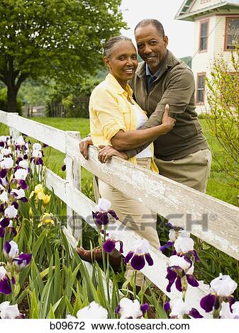 Portrait of a senior woman and a senior man standing near a fence View Large Photo Image Stock Image - Portrait of a senior woman and a senior man standing near a fence. Fotosearch