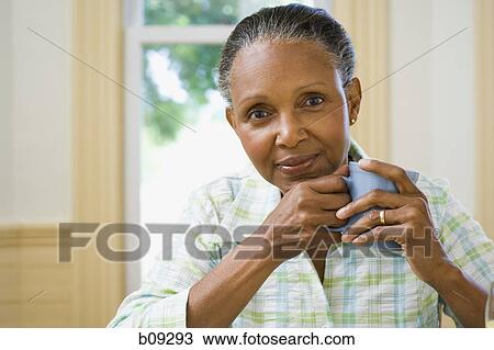 Portrait of a senior woman holding a cup of coffee View Large Photo Image Stock Image - Portrait of a senior woman holding a cup of coffee. Fotosearch