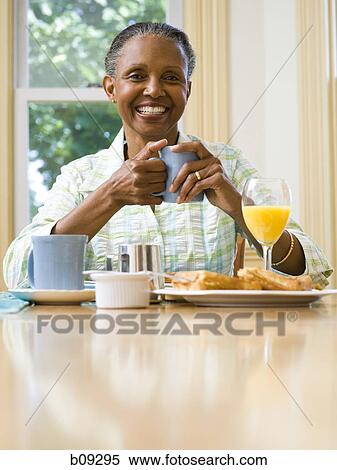 Portrait of a senior woman holding a cup of coffee at the breakfast table View Large Photo Image Stock Photography - Portrait of a senior woman holding a cup of coffee at the breakfast table. Fotosearch