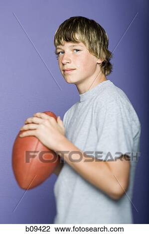 Portrait of a teenage boy holding a rugby ball View Large Photo Image Stock Image - Portrait of a teenage boy holding a rugby ball. Fotosearch