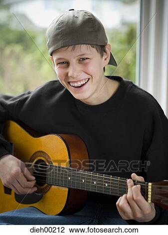 Portrait of a teenage boy playing the guitar View Large Photo Image Stock Image - Portrait of a teenage boy playing the guitar. Fotosearch