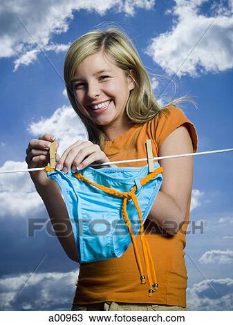 Portrait of a teenage girl drying a bikini bottom on a clothesline View Large Photo Image Stock Image - Portrait of a teenage girl drying a bikini bottom on a clothesline. Fotosearch