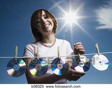 Portrait of a teenage girl drying CDs on a clothesline View Large Photo Image Stock Photography - Portrait of a teenage girl drying CDs on a clothesline. Fotosearch