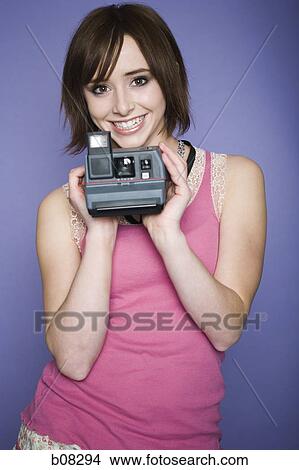 Portrait of a teenage girl holding a camera View Large Photo Image Picture - Portrait of a teenage girl holding a camera. Fotosearch