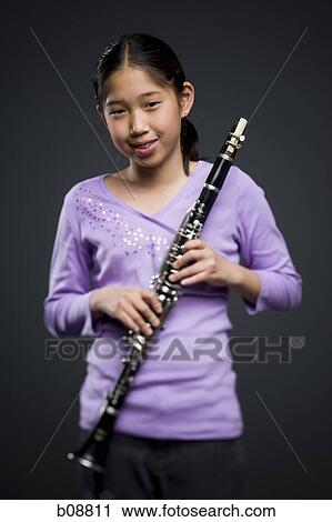 Portrait of a teenage girl holding a clarinet View Large Photo Image Stock Image - Portrait of a teenage girl holding a clarinet. Fotosearch