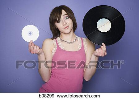 Portrait of a teenage girl holding a record and a CD View Large Photo Image Stock Photo - Portrait of a teenage girl holding a record and a CD. Fotosearch