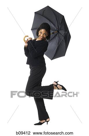 Stock Image - Portrait of a teenage girl holding an umbrella. Fotosearch