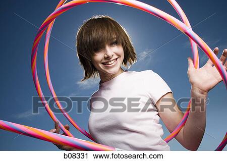Portrait of a teenage girl holding hula hoops View Large Photo Image Stock Image - Portrait of a teenage girl holding hula hoops. Fotosearch