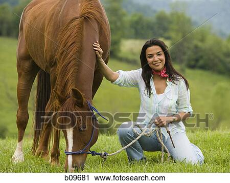 Portrait of a woman holding the reins of a horse View Large Photo Image Stock Image - Portrait of a woman holding the reins of a horse. Fotosearch