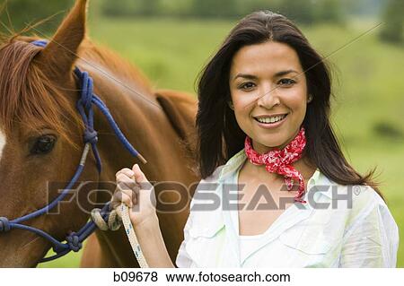 Portrait of a woman holding the reins of a horse View Large Photo Image Stock Photo - Portrait of a woman holding the reins of a horse. Fotosearch