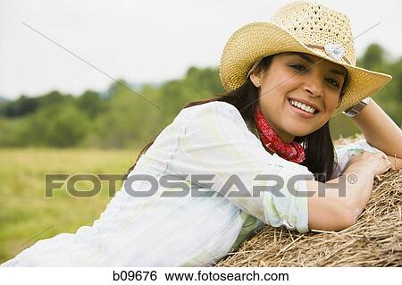 Portrait of a woman lying on a hay bale View Large Photo Image Stock Photograph - Portrait of a woman lying on a hay bale. Fotosearch